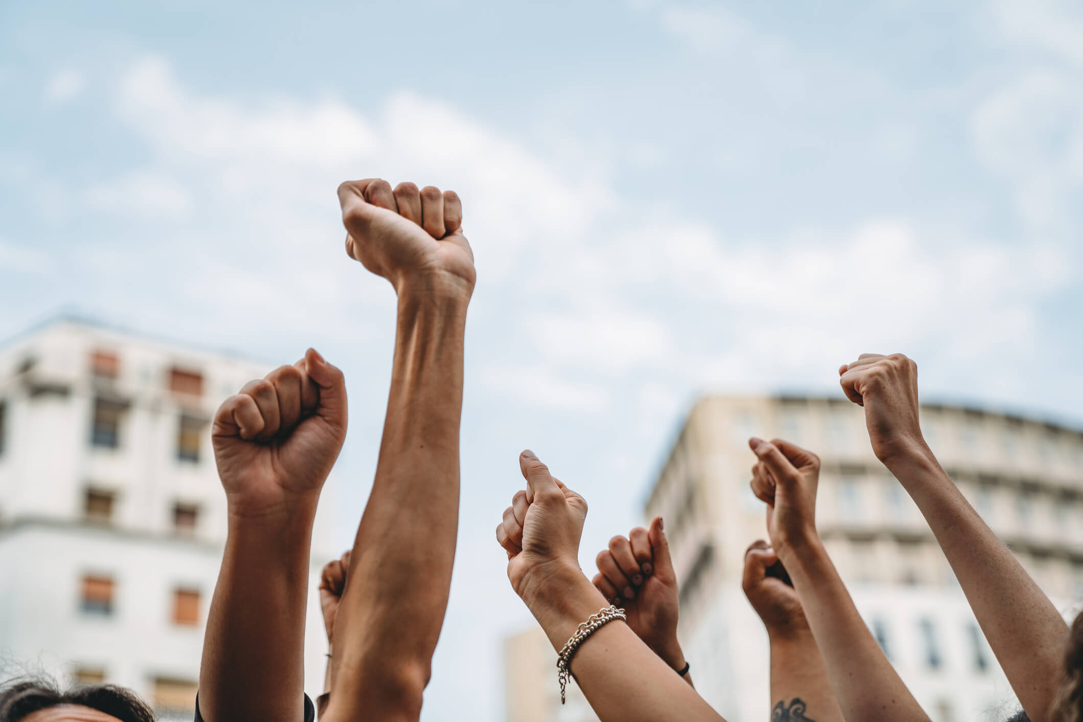 People's fists in the air demanding action