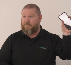 Screenshot of Kyle, holding up phone